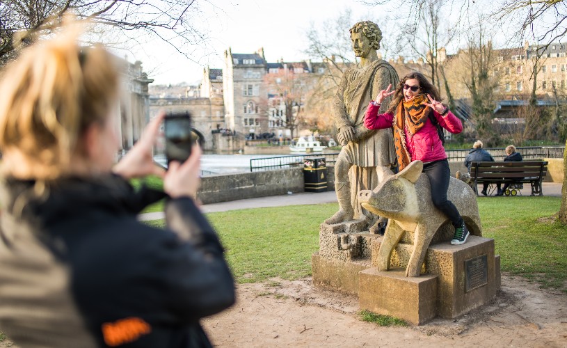 Woman posing on the King Bladud and pig statue
